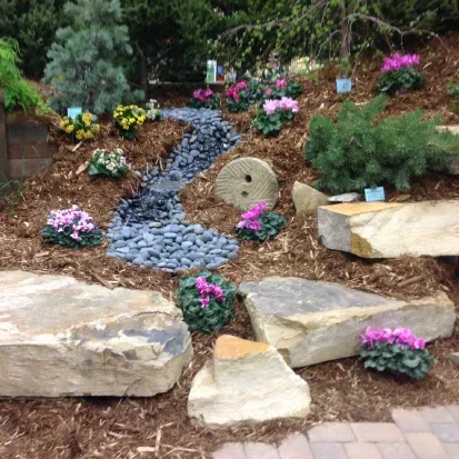 Landscape boulder placement in Loretto MN adding texture and structure to residential outdoor designs