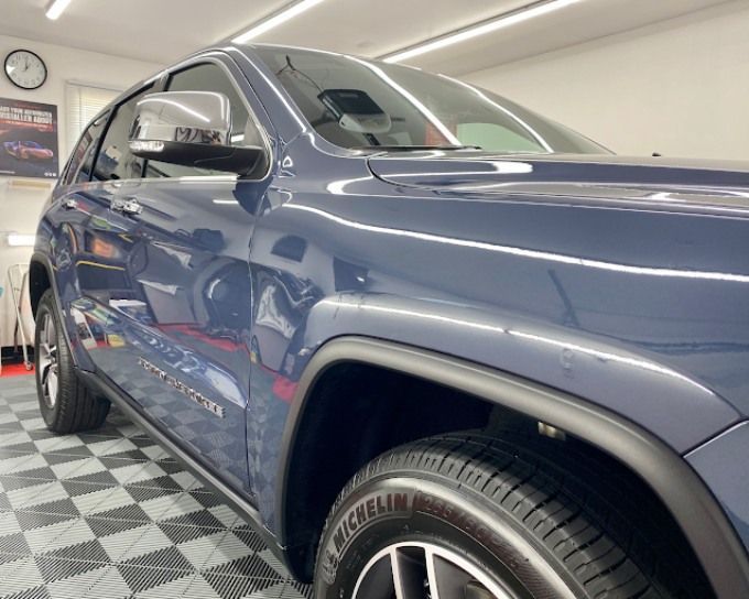 Blue Jeep SUV on checkered shop floor showing paint protection film coverage options