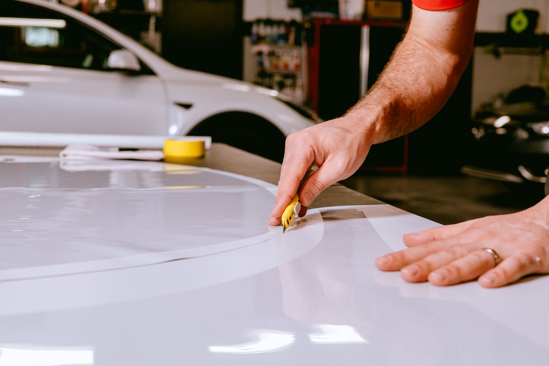 a man is measuring the roof of a car with a tape measure .