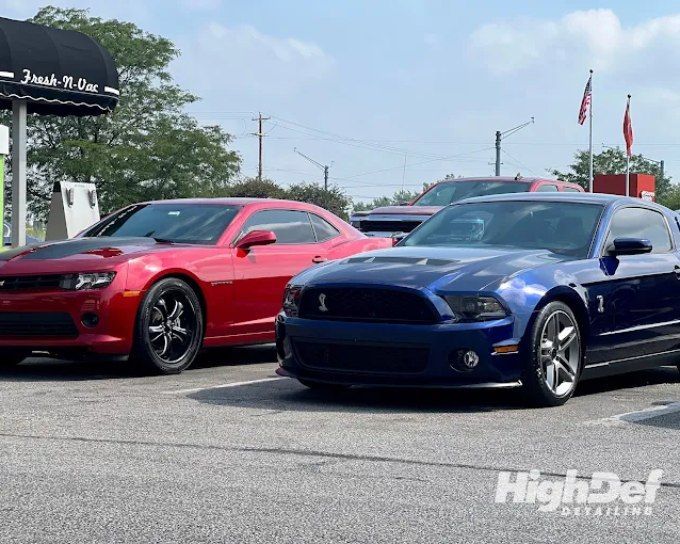 Red Chevrolet Camaro and blue Shelby Mustang showing auto window tinting film types for cars
