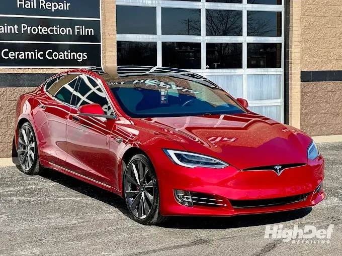Red sports car with auto window tinting applied, highlighting improved aesthetics and interior protection. 