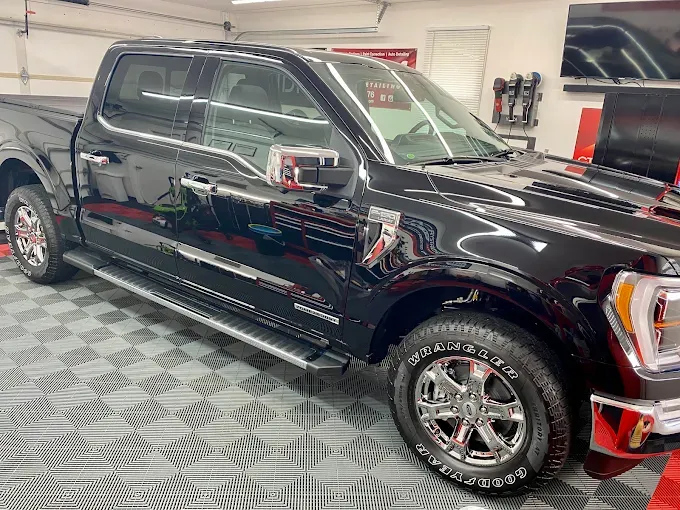 Black pickup truck with freshly installed paint protection film, showing a shiny, well-protected exterior ready for long-term upkeep.
