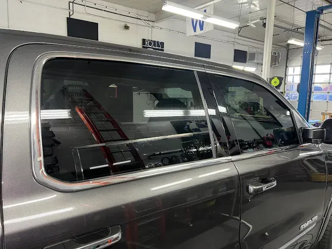 Close-up of truck window with auto window tinting, demonstrating professional installation and a smooth finish. 

