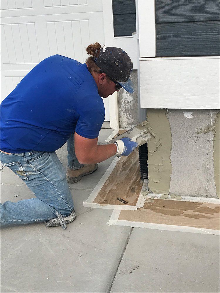 Man Wearing Blue Shirt Working on House Foundation — Layton, UT — H & C Foundation Plastering