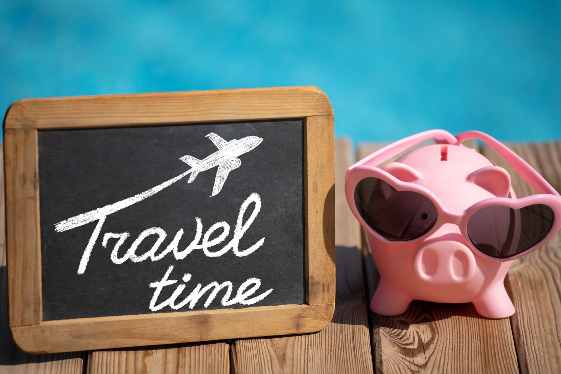 Piggy bank and travel sign representing vacation savings and planning an Aruba getaway.