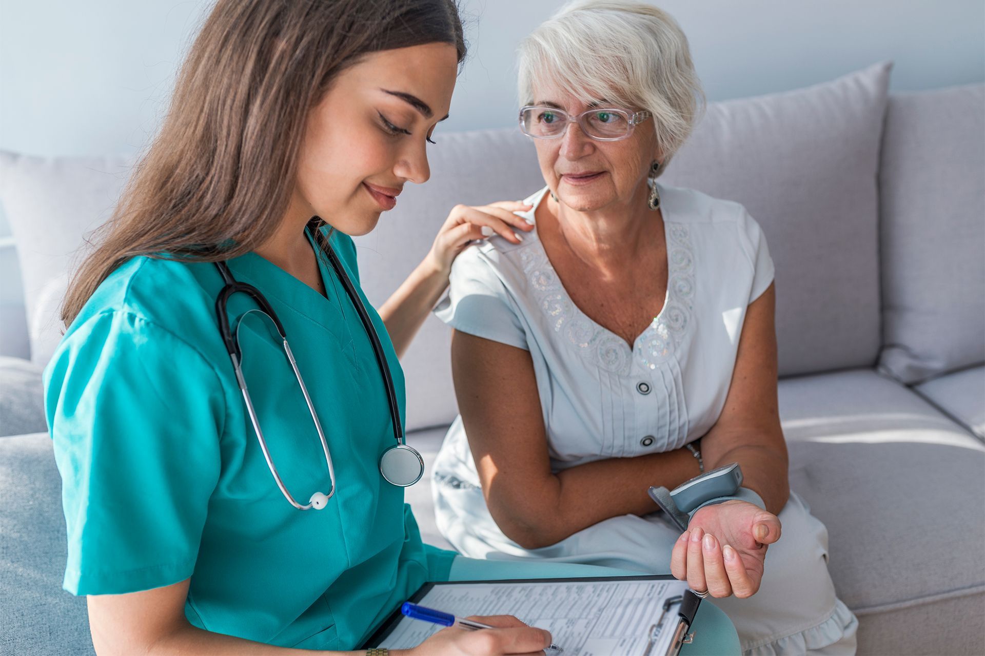 Caregiver Measuring Blood Pressure of Elderly Woman at Home