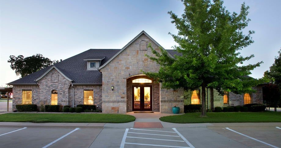 A large brick house with a parking lot in front of it