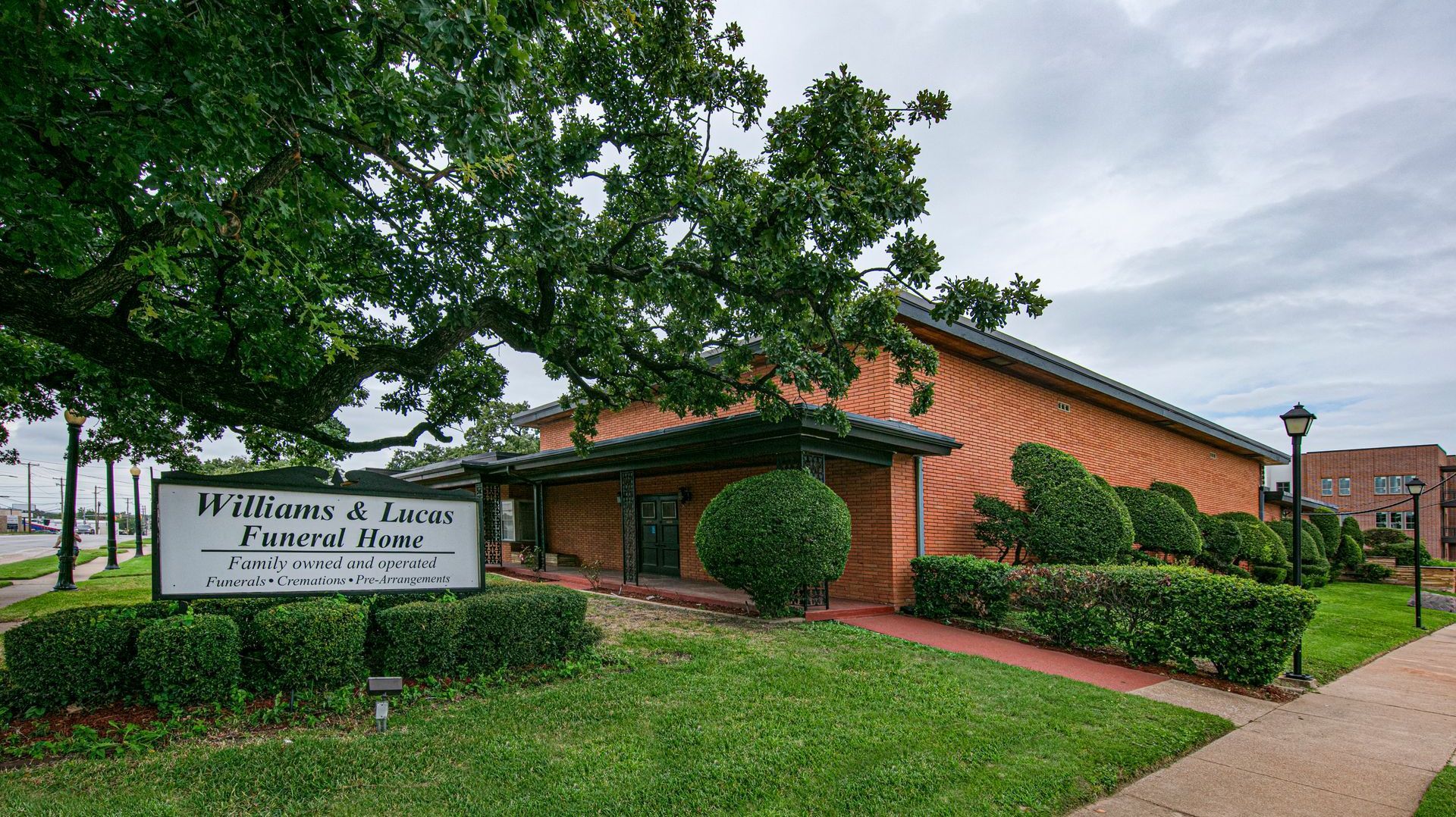 A sign for williams and lucas funeral home is in front of a building.