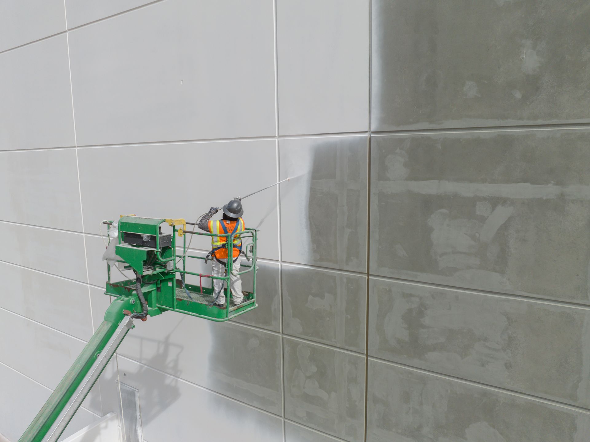 Worker painting the exterior of a business.