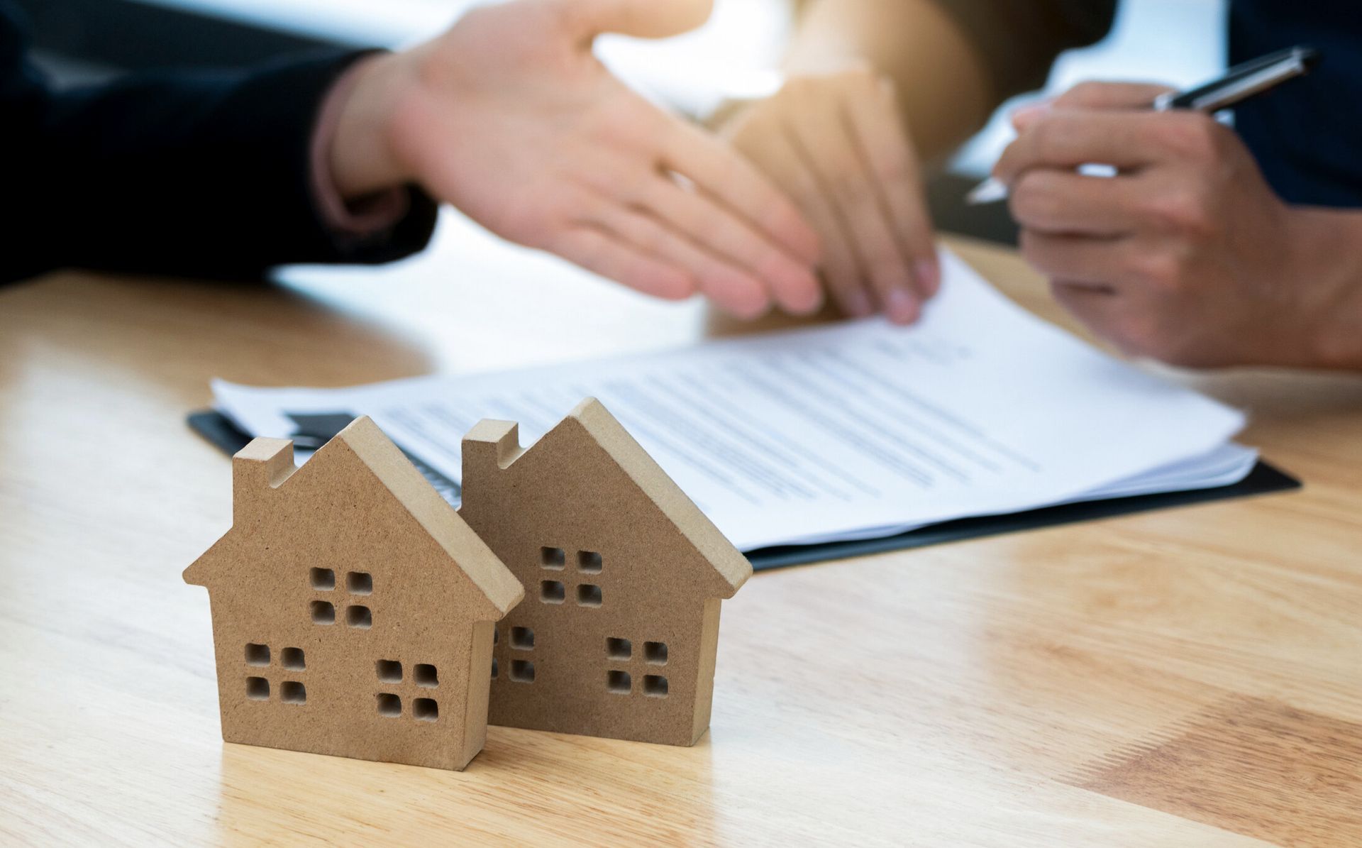 A close-up of a client signing a document in a title agency