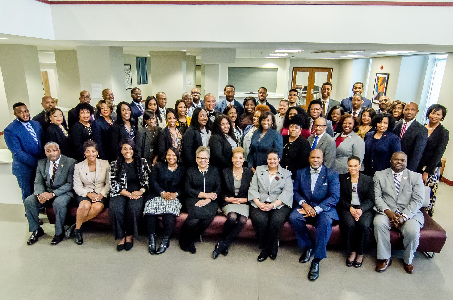 Group of people in business attire posing in an office setting.