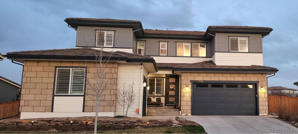 Two-story suburban house with a double garage at dusk