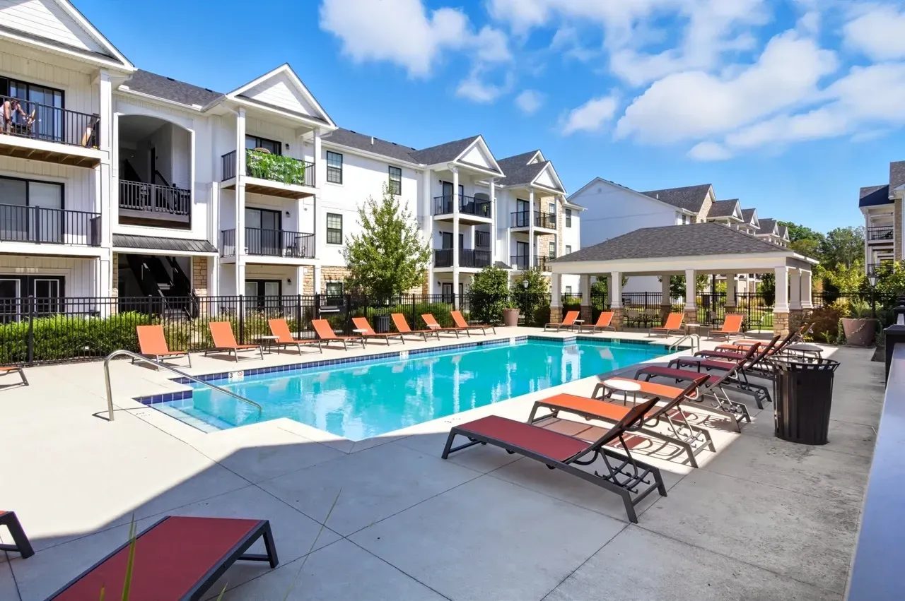 Resort-style swimming pool with lounge chairs and a covered cabana at a multifamily property.