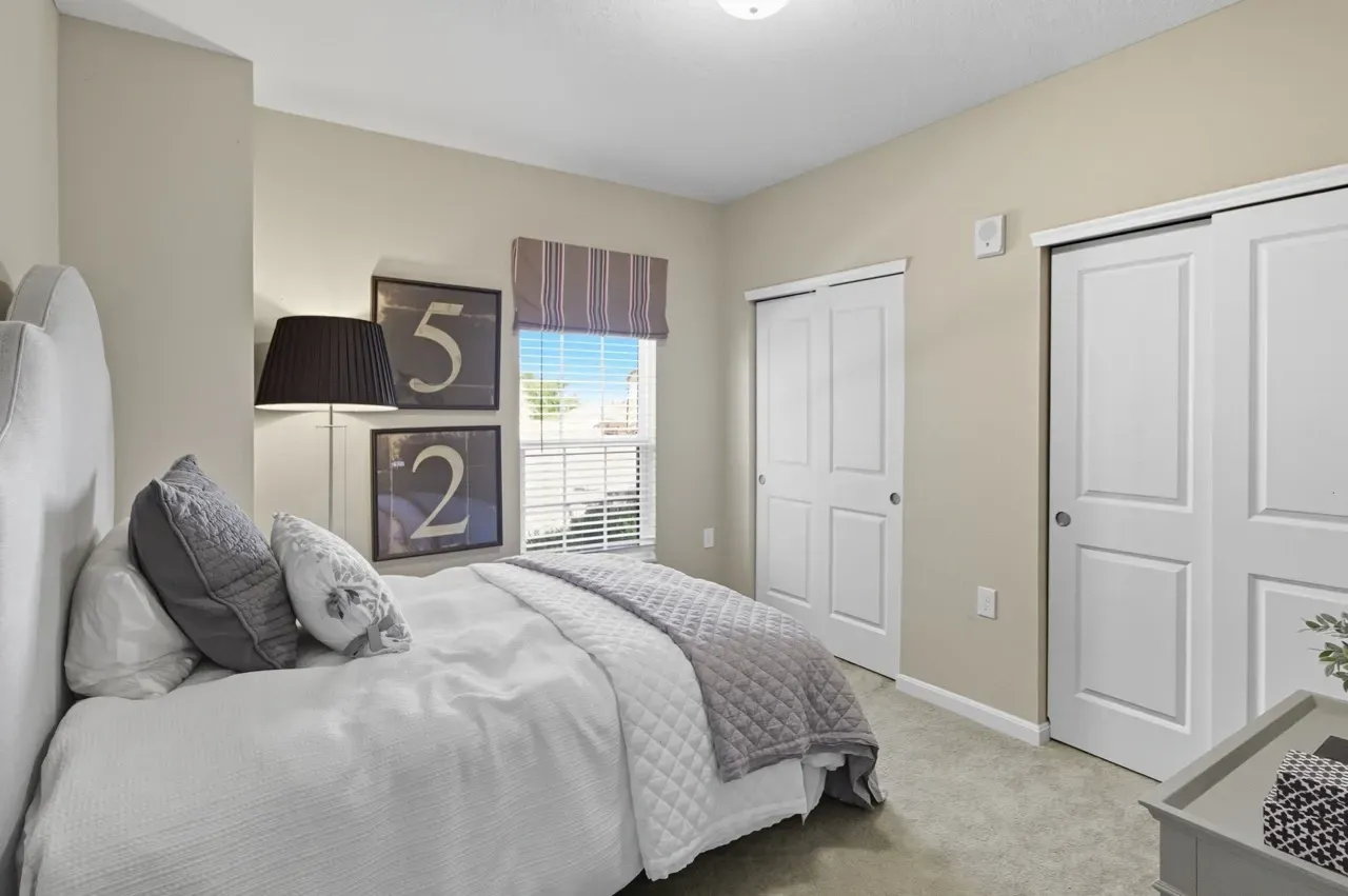 Comfortable bedroom with a queen-sized bed, white bedding, and decorative pillows.