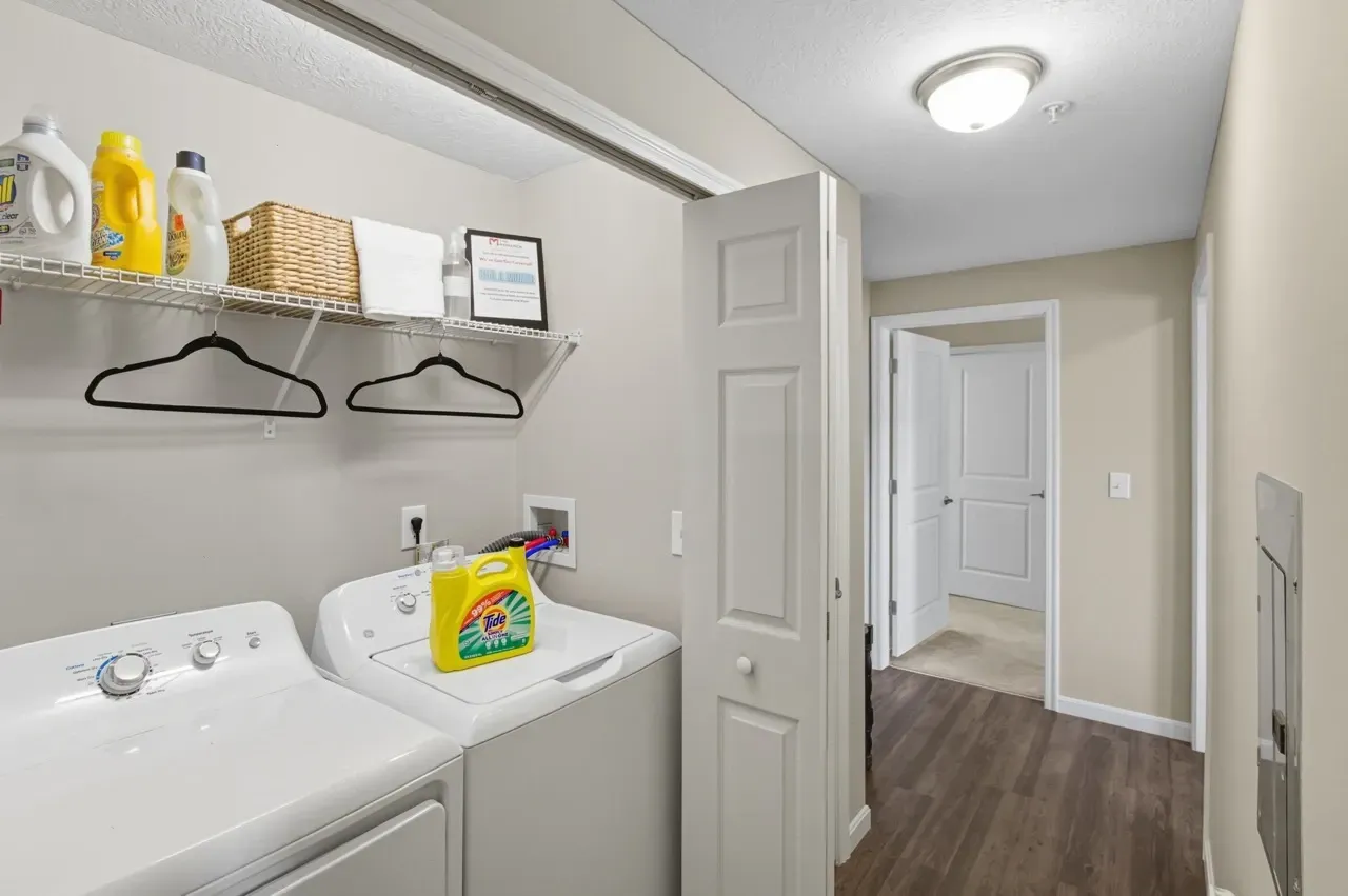 Washer and dryer with laundry supplies in a hallway