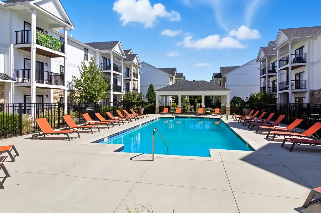 Outdoor swimming pool with lounge chairs and a cabana.