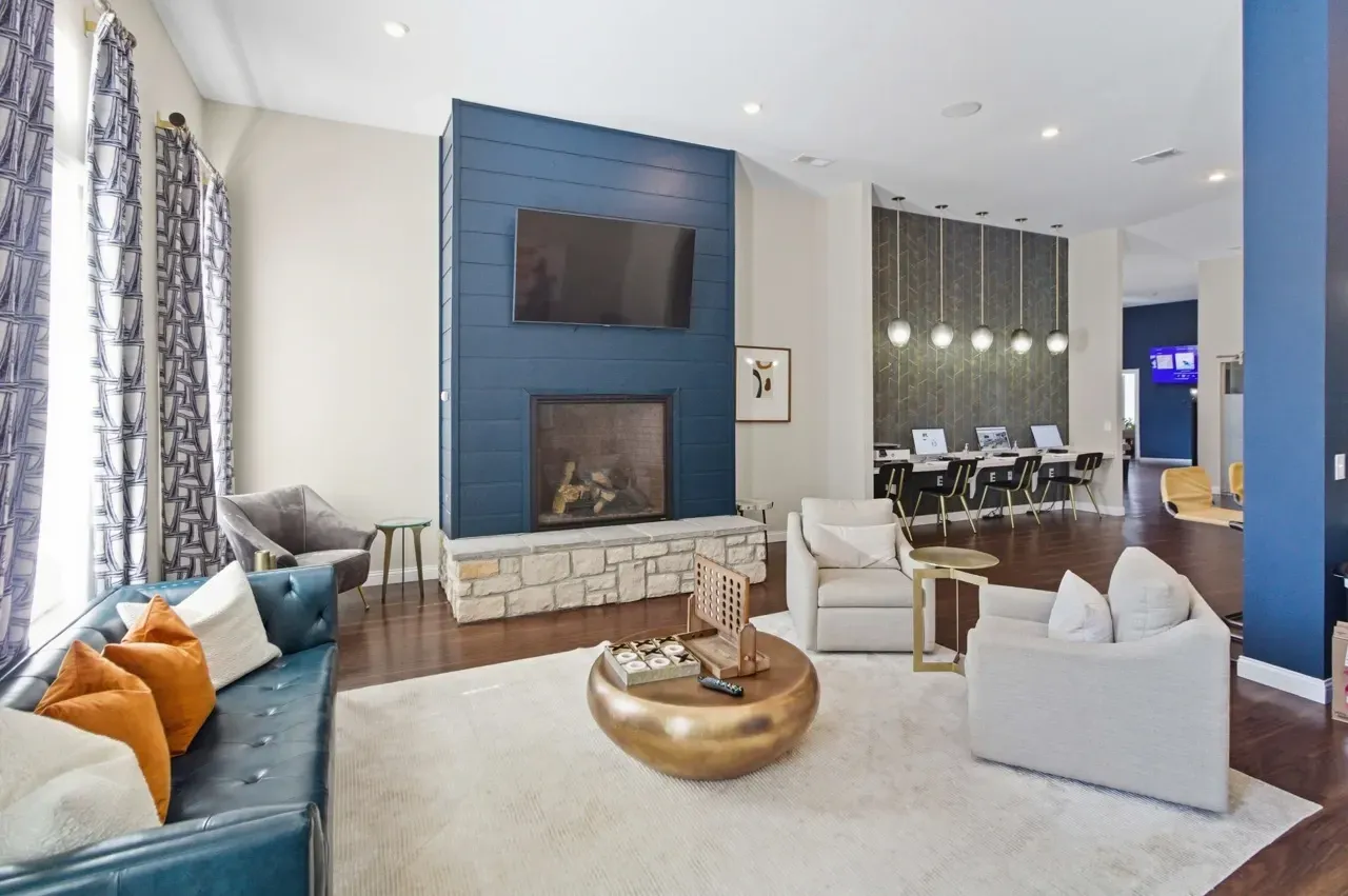 Lounge area with fireplace, seating, and a business center with computers.