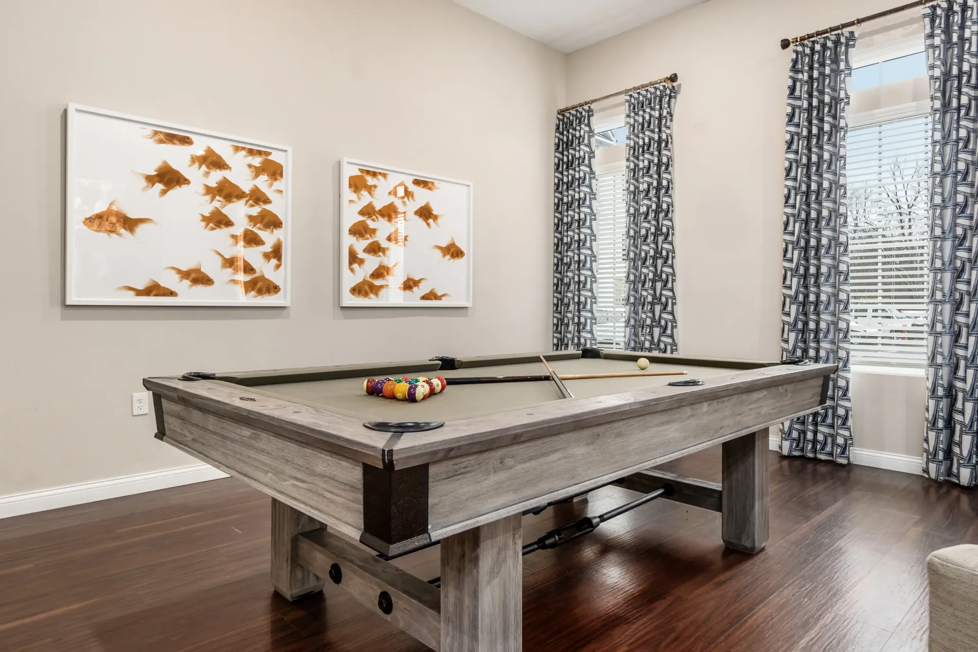 Game room with a pool table and artwork of goldfish.