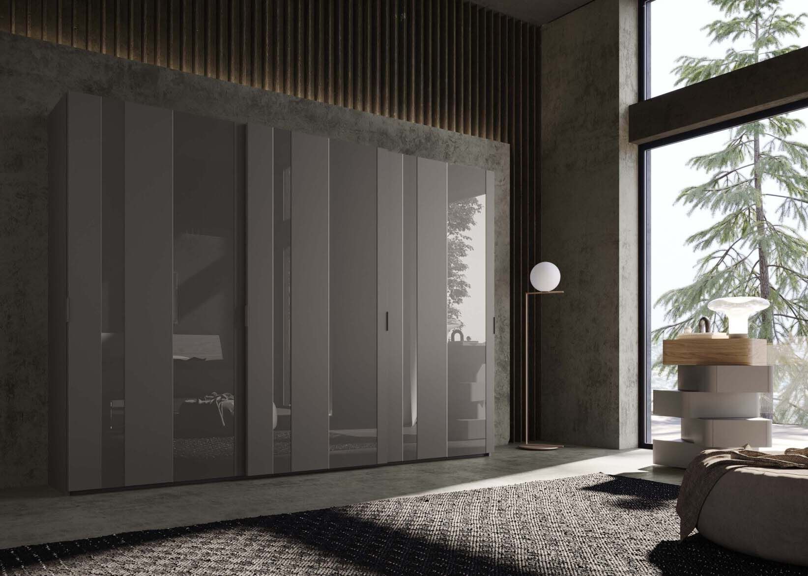 Camera da letto moderna con armadio a specchio grigio, grande finestra con vista sugli alberi e tappeto a fantasia.