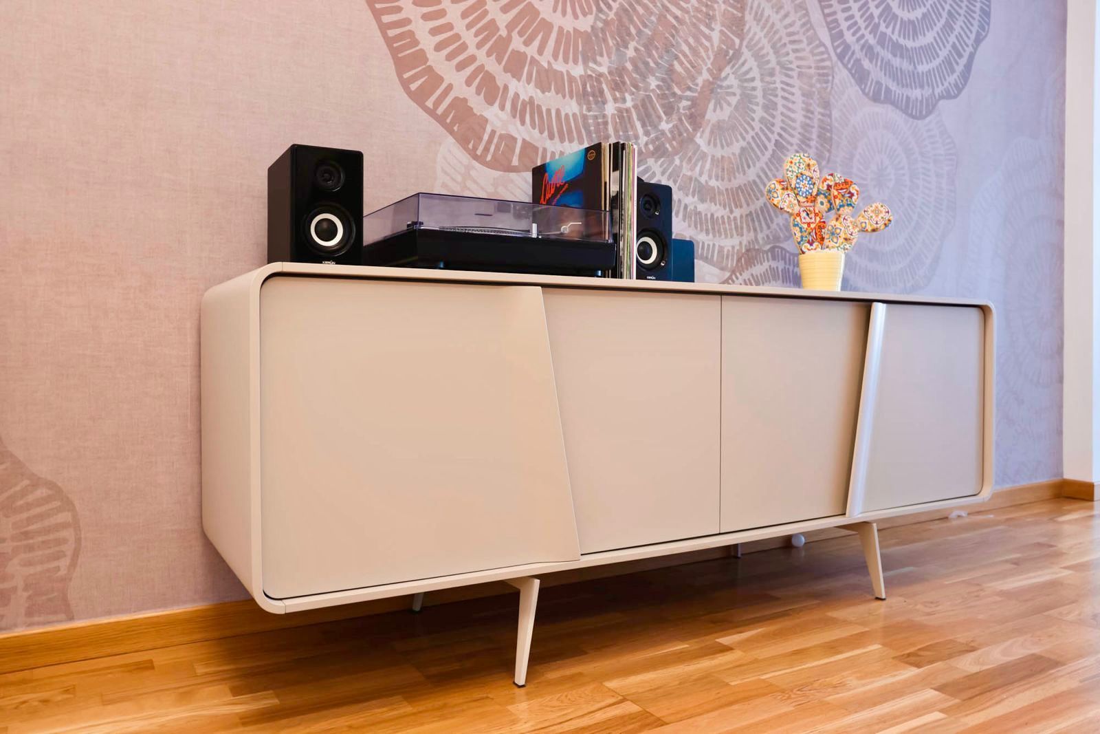 Credenza moderna bianca con altoparlanti e decorazioni in una stanza minimalista