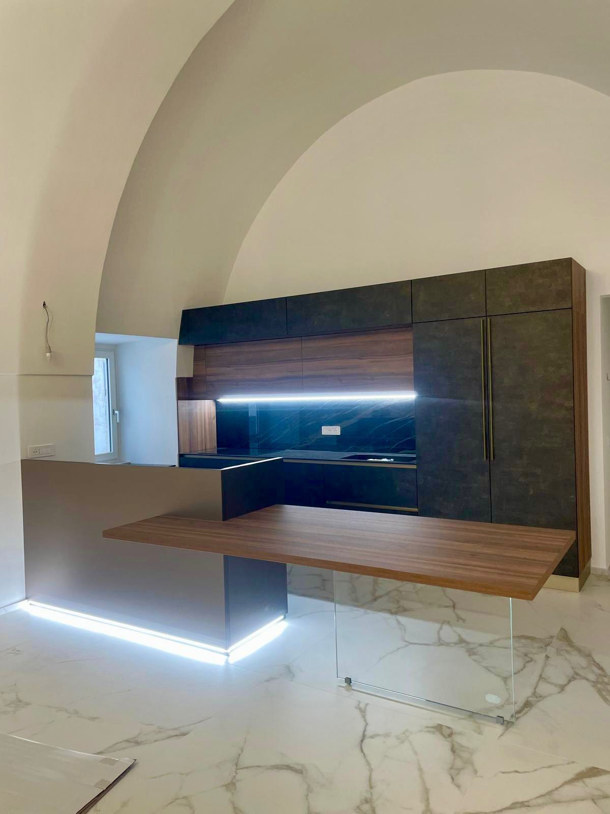 Parete attrezzata in legno scuro con nicchia per la TV ed eleganti ante, in una stanza moderna.