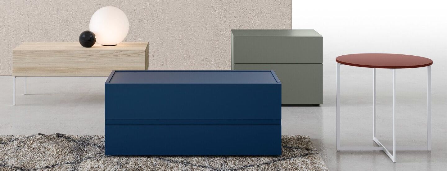 Set di mobili per camera da letto moderni in legno blu, verde e naturale, con uno sgabello e una lampada rotonda.