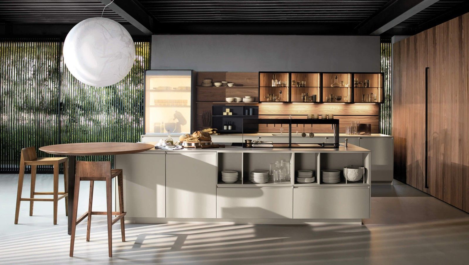 Cucina moderna con isola, mobili in legno e tavolo rotondo con sgabelli.