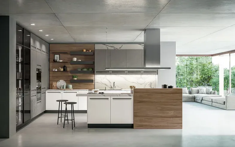 Cucina moderna con mobili bianchi e in legno, isola, cappa in acciaio inox, pavimenti in cemento e finestre a tutta altezza.
