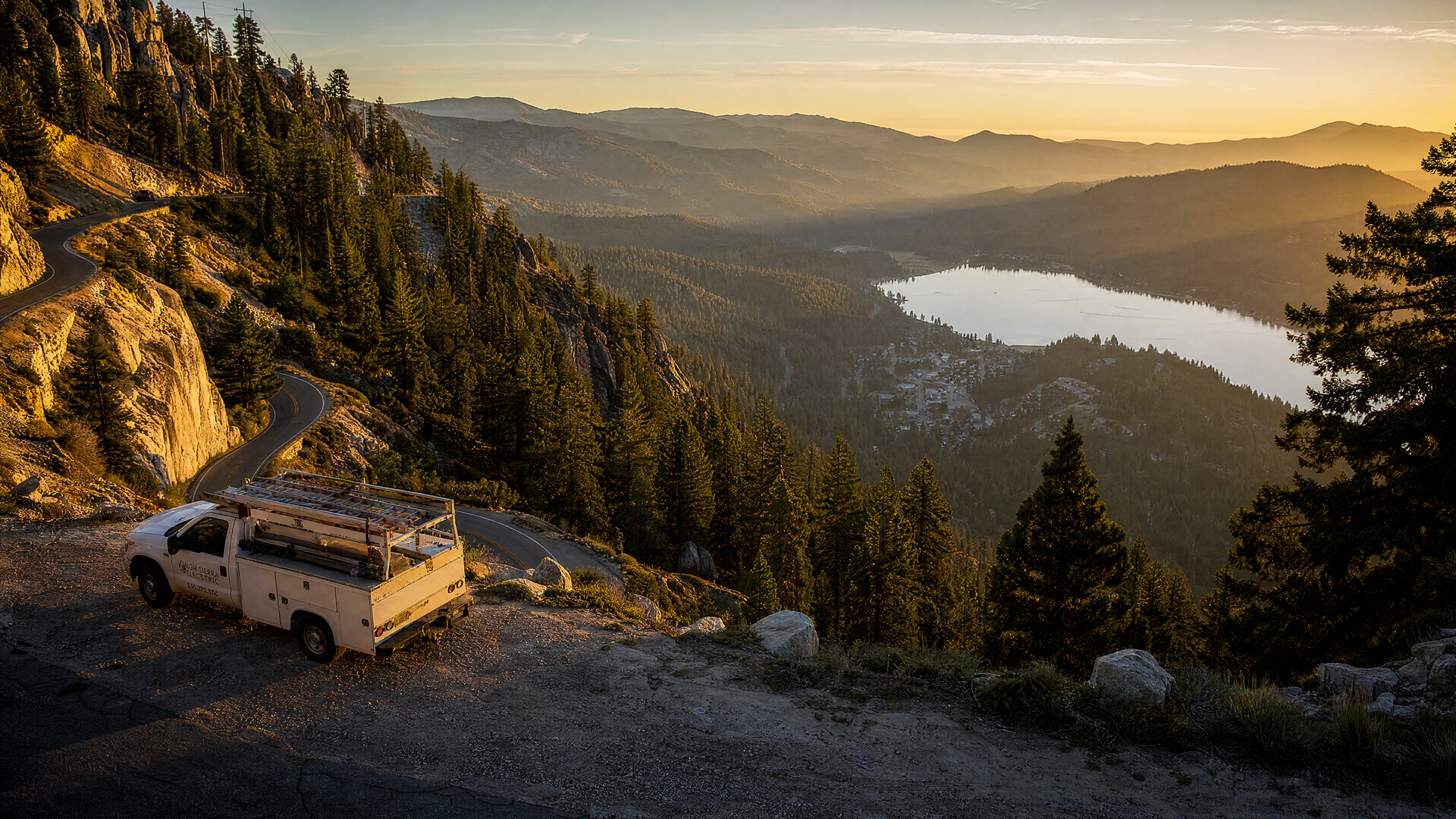 An electrician's service truck on the switchback road above Green Valley Lake, CA, with the alpines