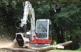 A red and white excavator is cutting down trees in a forest.