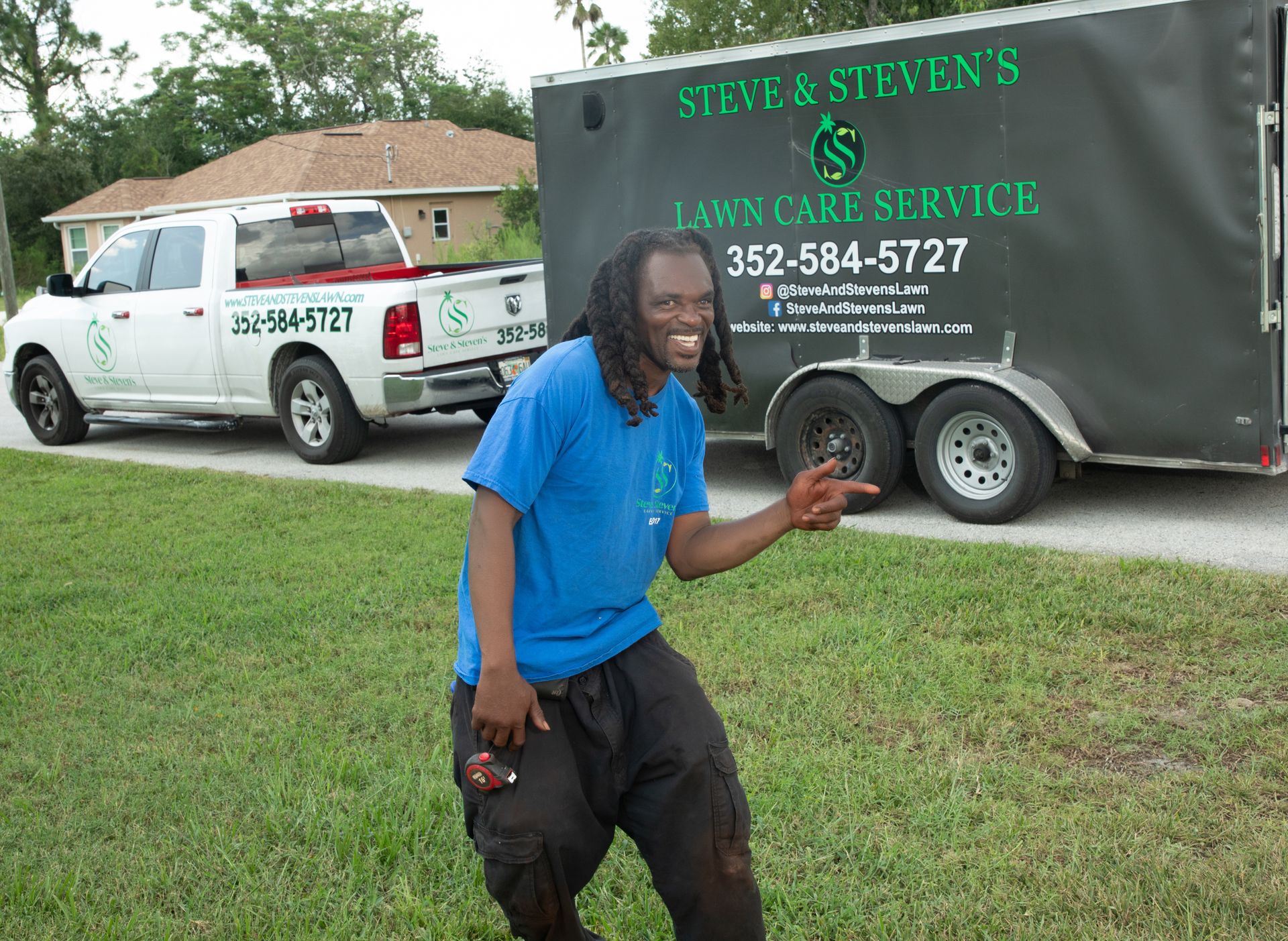A man standing in front of a trailer that says steve & steven 's lawn care service