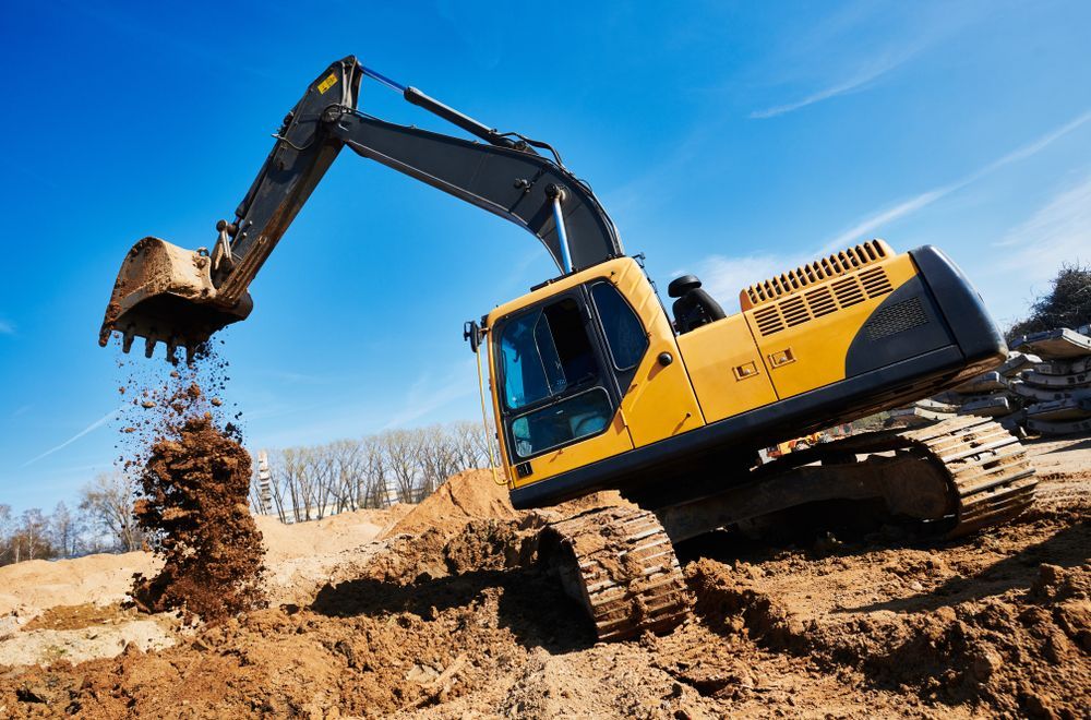 Yellow Excavator Digging Dirt, Against a Bright Blue Sky — Ace Clearing & Mulching In Forster, NSW