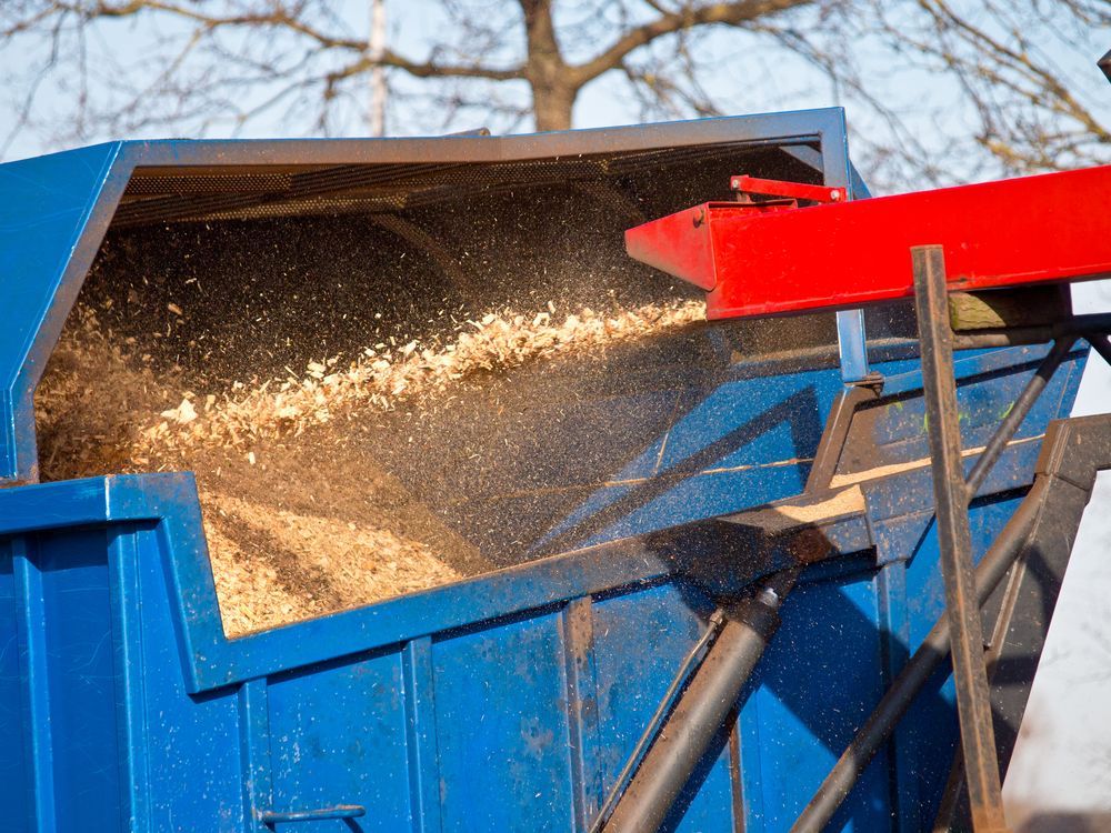 Blue Wood Chipper With Wood Chips Blowing Out — Ace Clearing & Mulching In Pacific Palms, NSW