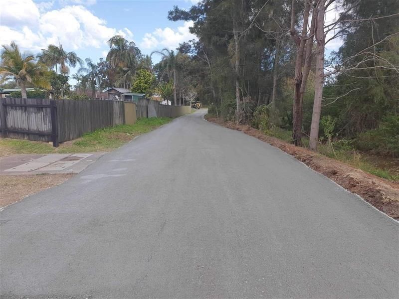 Newly Paved Road in a Residential Area, Flanked by a Wooden Fence — Ace Clearing & Mulching In Old Bar, NSW