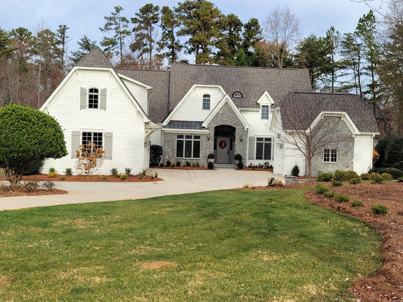 A large white house with a lush green lawn in front of it