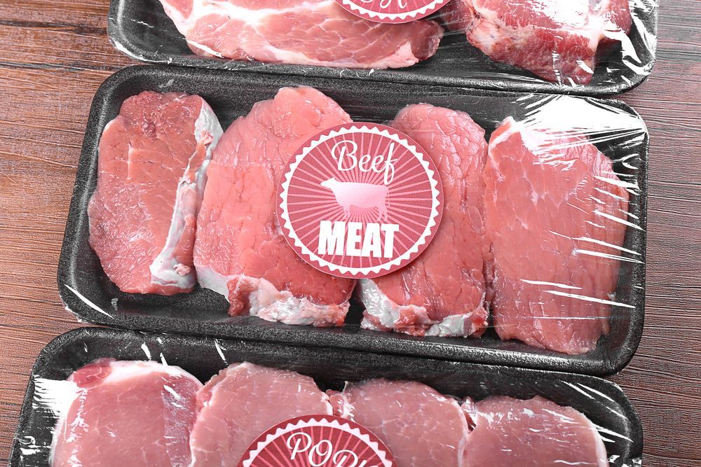 Three Trays Of Beef Meat Are Sitting On A Wooden Table — McGrath Meats In Taree, NSW