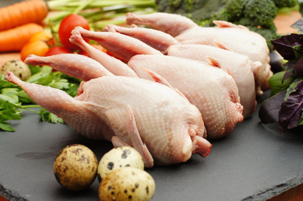 A Slate Cutting Board Topped With Raw Quail, Potatoes And Vegetables — McGrath Meats In Taree, NSW
