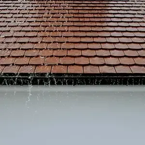 Rain falling on a terracotta-tiled roof beneath an overhang.