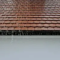 Rain falling on a terracotta-tiled roof beneath an overhang.