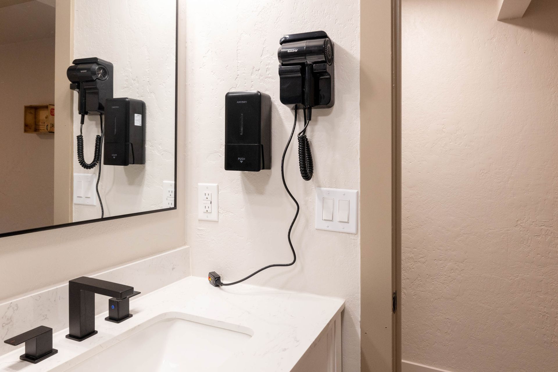 Hotel bathroom sink with wall-mounted telephone, mirror, and beige shower curtain