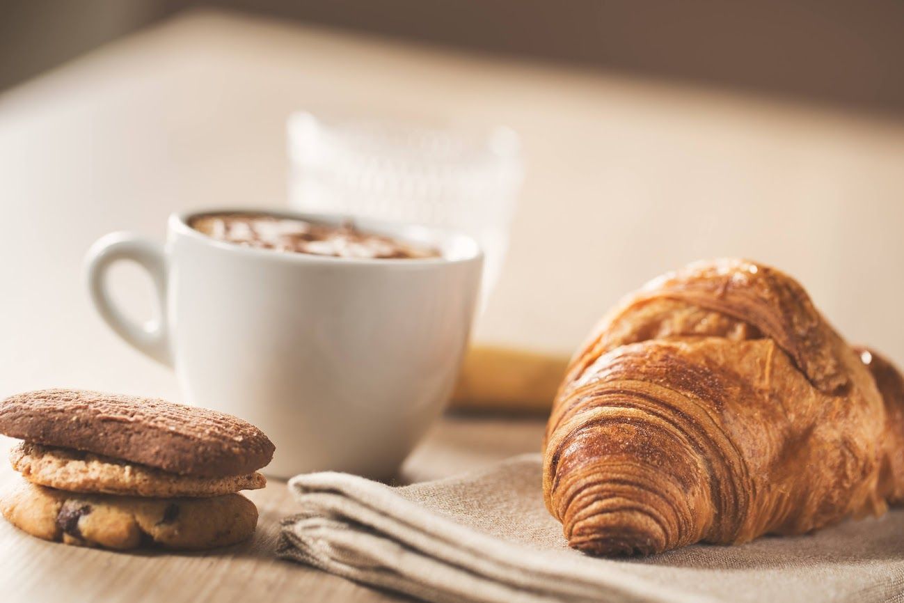 Tazza di caffè, croissant e biscotti