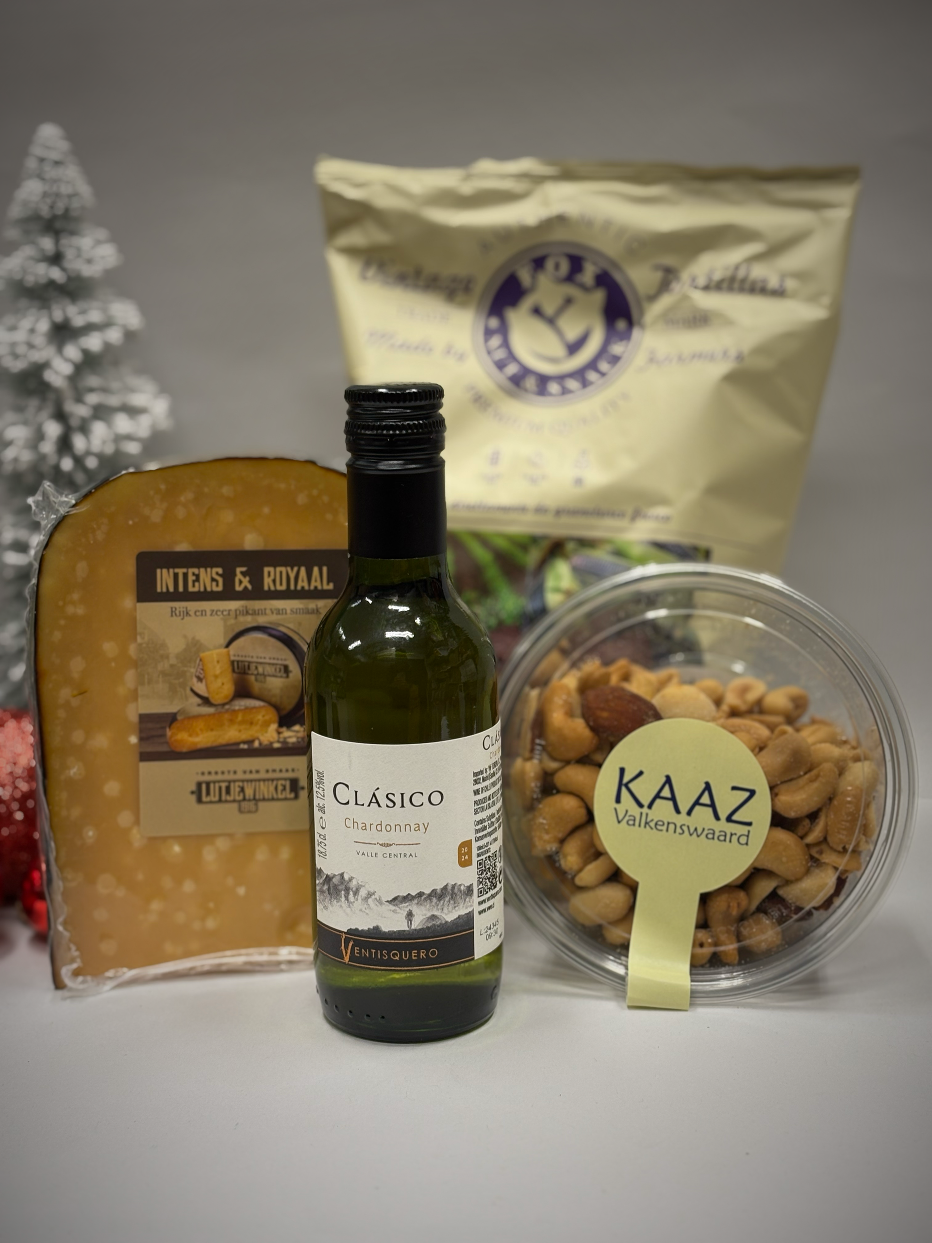 Kaas, wijn, noten en crackers in een geschenkmand; feestelijke setting.