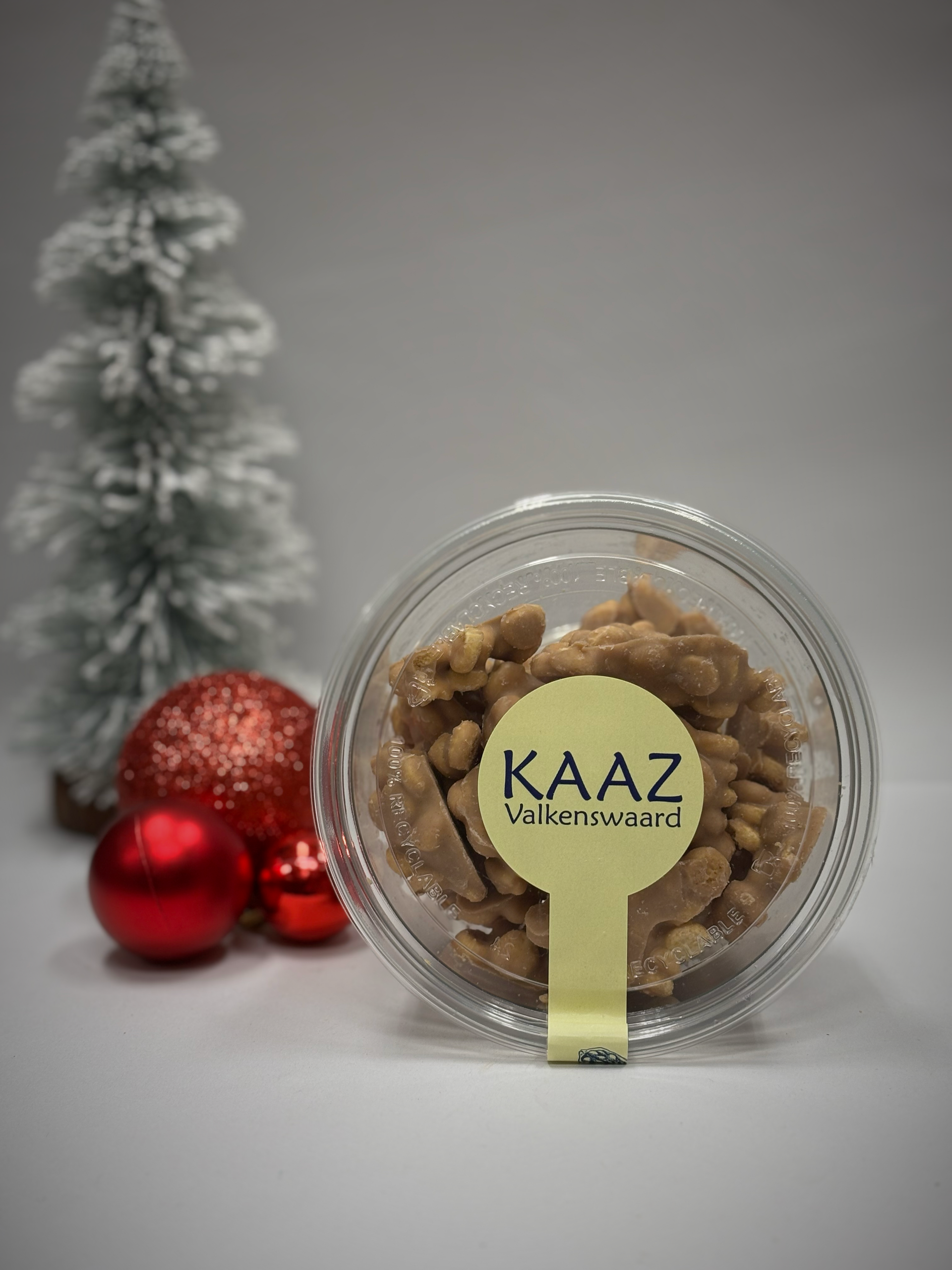 Een doorzichtige plastic bak vol karamelsnoepjes met een etiket, voor de kerstversiering.