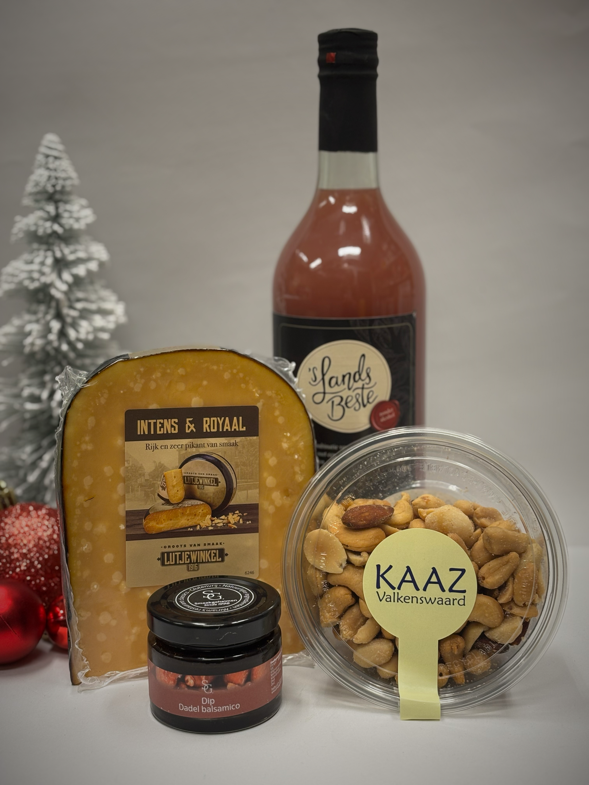 Kaas, noten, jam en een fles roze vloeistof, mogelijk wijn, als cadeau voor de feestdagen.