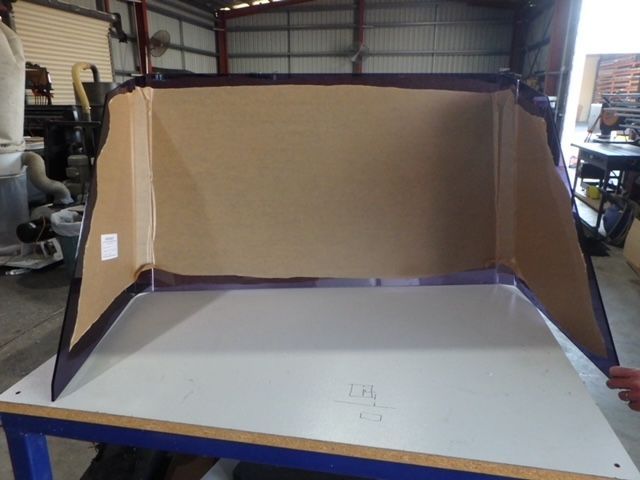 Large beige acoustic panel mounted in a workshop behind a gray worktable. — Advanced Poly in Darwin, NT — Advanced Poly in Darwin, NT 