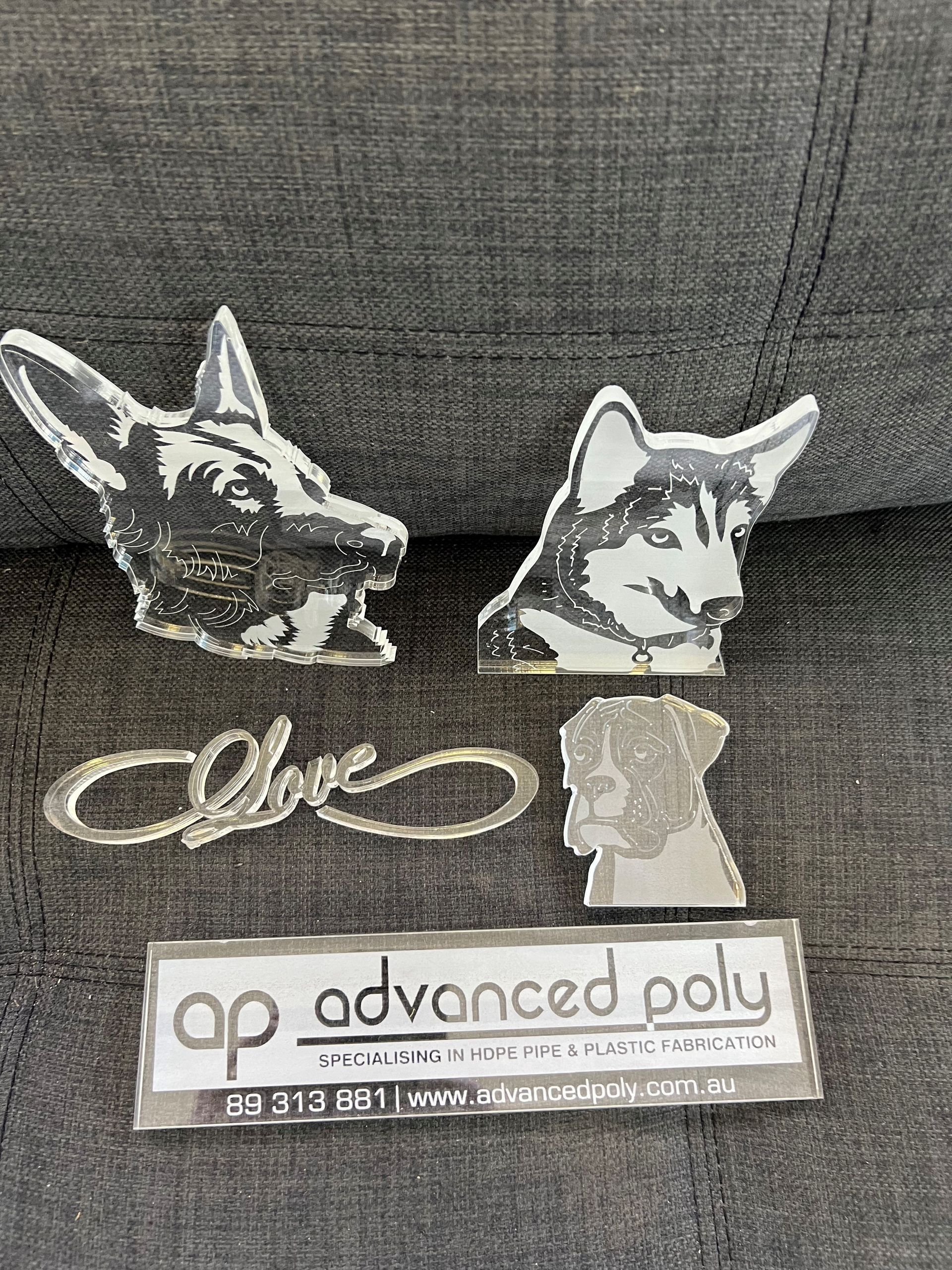 Assorted acrylic pet-shaped cutouts and an “ap advanced poly” label on a gray fabric surface — Advanced Poly in Darwin, NT