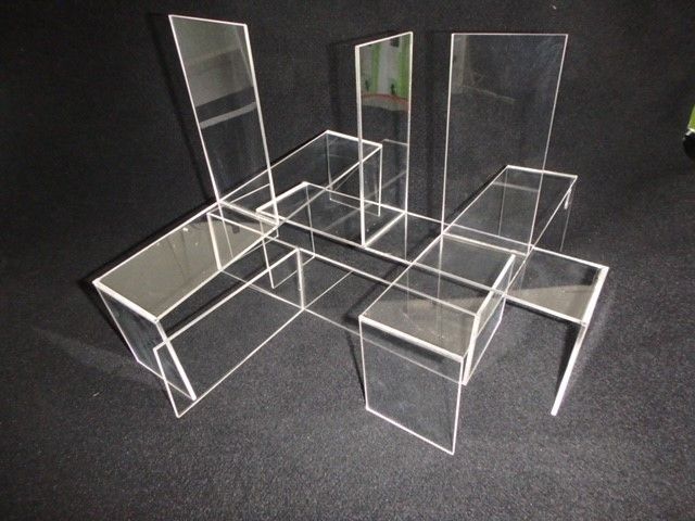 Transparent acrylic chairs arranged in a geometric cluster on a dark carpeted floor — Advanced Poly in Darwin, NT — Advanced Poly in Darwin, NT 