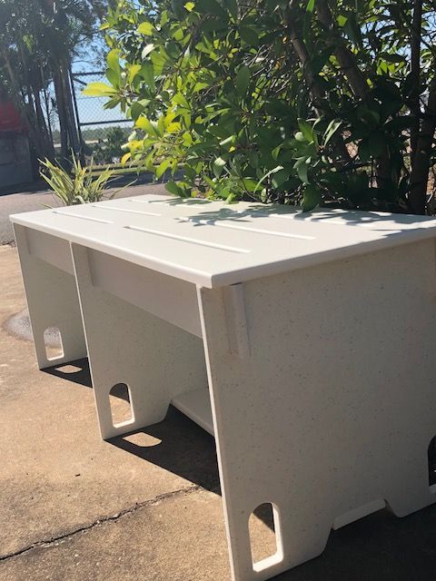 White outdoor bench-style storage table beside a leafy bush on a sunny patio — Advanced Poly in Darwin, NT 