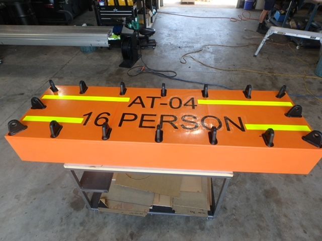 Orange safety float labeled “AT-04 16 PERSON” in a workshop — Advanced Poly in Darwin, NT — Advanced Poly in Darwin, NT — Advanced Poly in Darwin, NT — Advanced Poly in Darwin, NT — Advanced Poly in Darwin, NT 