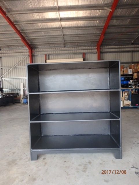 Gray metal shelving unit in a warehouse with a corrugated roof and concrete floor — Advanced Poly in Darwin, NT